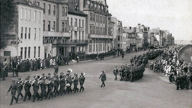 Немецкие войска маршируют вдоль набережной Гернси во время оккупации во время Второй мировой войны