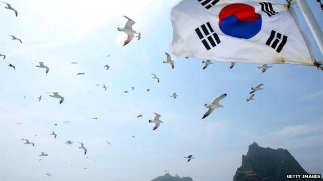 Южнокорейский флаг развевается на борту туристического судна возле контролируемых Кореей островов в Японском море - 16 июля 2008 года, известного как Такэсима в Японии и Докдо в Южной Корее