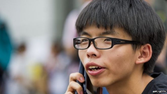 Джошуа Вонг разговаривает по телефону в Гонконге 2 октября 2014 года