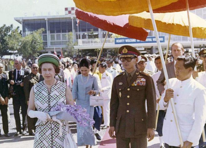 Британская королева Елизавета II гуляет с королем Пумипоном во время подготовки к посадке в самолет в аэропорту Чиангмая, Таиланд, 1972 год