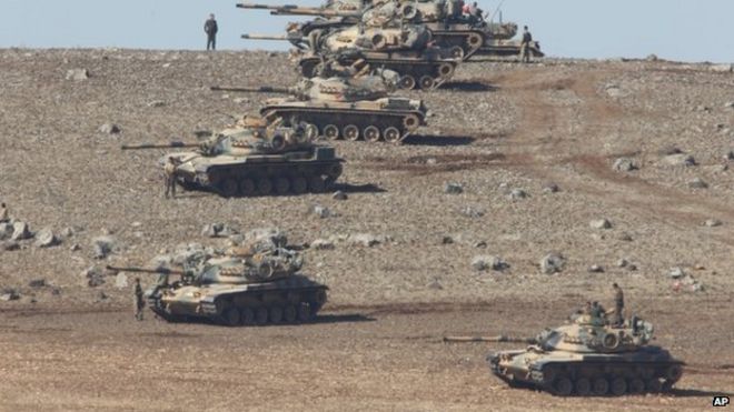 Турецкие солдаты с танками удерживают позиции на вершине холма на окраине Суруч, на границе Турции и Сирии