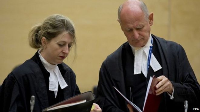 Адвокаты Ухуру Кеньятты, Стивен Кей и Джиллиан Хиггинс, изучают юридические документы в Международном уголовном суде в Нидерландах 8 октября 2014 года