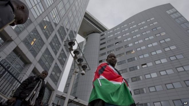 Сторонник президента Кении Ухуру Кениата ждет 8 октября 2014 года у Международного уголовного суда в Нидерландах