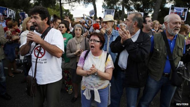 Протестующие принимают участие в демонстрации против сокращения государственных расходов в секторе здравоохранения за пределами больницы им. Карлоса III в Мадриде, где проходит лечение медсестра, заразившаяся Эболой, 8 октября 2014 г.
