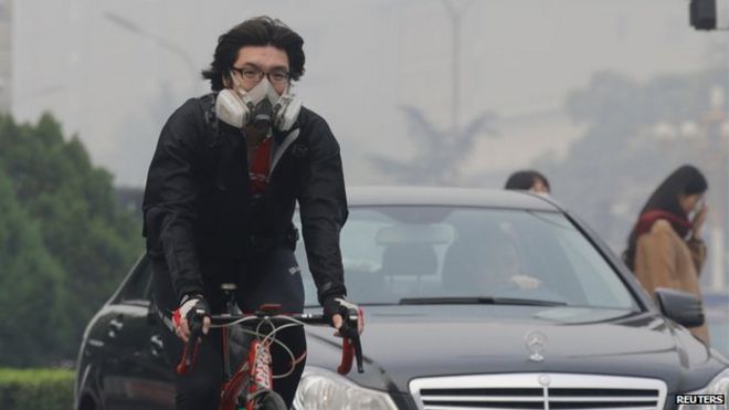 Велосипедист в респираторной маске на улицах Пекина (10 октября)