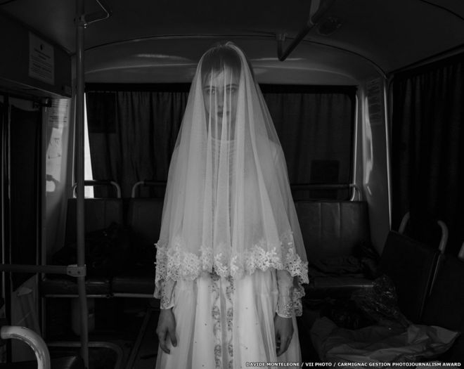 14-летняя Рада примеряет свадебное платье, созданное ее сестрой, на борту автобуса во время репетиции съемок фильма о депортации чеченцев.