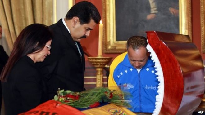 Президент Венесуэлы Николас Мадуро (в центре), первая леди Силия Флорес (слева) и председатель Национального собрания Диосдадо Кабелло (справа) стоят перед гробом Робертом Серра во время похорон в Каракасе 2 октября 2014 года