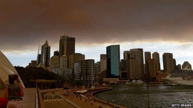 Дым и пепел от горящих пожаров в штате Новый Южный Уэльс покрывают городской пейзаж Сиднея 17 октября 2013 г.