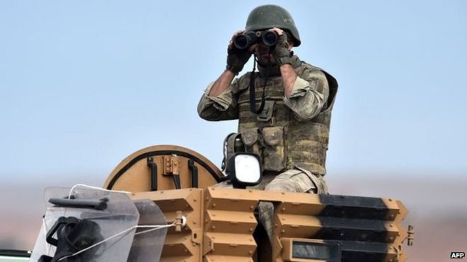Турецкий солдат наблюдает за событиями в Кобане