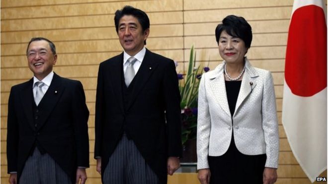 Премьер-министр Японии Синдзо Абэ (C) позирует для СМИ вместе с новым министром экономики, торговли и промышленности Йоити Миядзава (слева) и новым министром юстиции Йоко Камикавой в официальной резиденции Абэ в Токио, Япония, 21 октября 2014 года