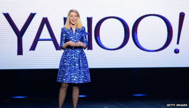 Марисса Майер перед логотипом Yahoo