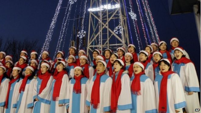 Вторник, 21 декабря 2010 года. Христиане Южной Кореи поют рождественскую песню перед гигантской стальной рождественской елкой на западной вершине горы, известной как Эгибонг, в Кимпхо, Южная Корея