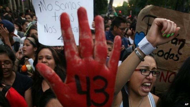 Демонстранты маршируют в знак протеста против исчезновения 43 учеников Сельского колледжа учителей Исидро Бургоса в Мехико 22 октября 2014 года