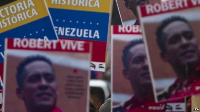 Плакаты с изображениями убитого венесуэльского законодателя Роберта Серры во время марша в Каракасе 18 октября 2014 года.