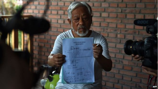 Организатор Пекинского независимого кинофестиваля Ли Сяньтин демонстрирует документ, выпущенный полицией после его освобождения