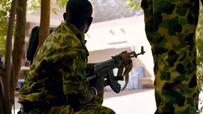 Буркинский солдат занимает позицию во дворе штаб-квартиры национального телевидения после того, как в районе Уагадугу 2 ноября 2014 года были произведены выстрелы