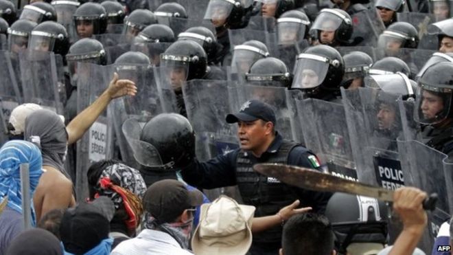 Протестующие противостоят ОМОНу во время акции протеста в аэропорту Акапулько 10 ноября 2014 года.
