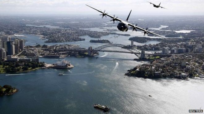 Два самолета Королевских австралийских военно-воздушных сил Геркулес пролетают над Сиднейским оперным театром и мостом Сидней-Харбор во время демонстрации, на этом раздаточном снимке, выпущенном Австралийскими силами обороны 10 сентября 2014 года