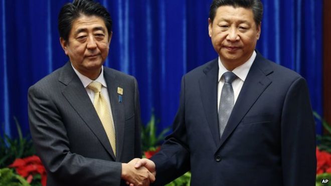 Премьер-министр Японии Синдзо Абэ проходит мимо китайского Си Цзиньпина во время церемонии приветствия саммита АТЭС в Международном конференц-центре на озере Янки, Пекин, Китай, 11 ноября 2014 года
