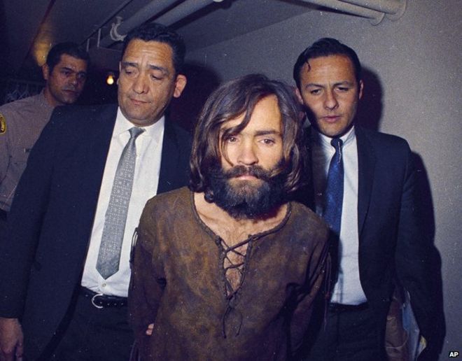 Чарльза Мэнсона сопровождают на суд по обвинению в убийстве заговора в связи с делом об убийстве Шарон Тейт, 1969 год, Лос-Анджелес