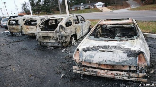 Обгоревшие останки автомобилей, которые были подожжены во время беспорядков в Деллвуде, штат Миссури - 25 ноября 2014 года