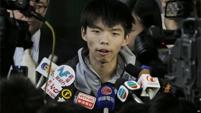 Выдающийся лидер студенческого протеста в Гонконге Джошуа Вонг беседует с журналистами перед судом в Гонконге 27 ноября 2014 г.