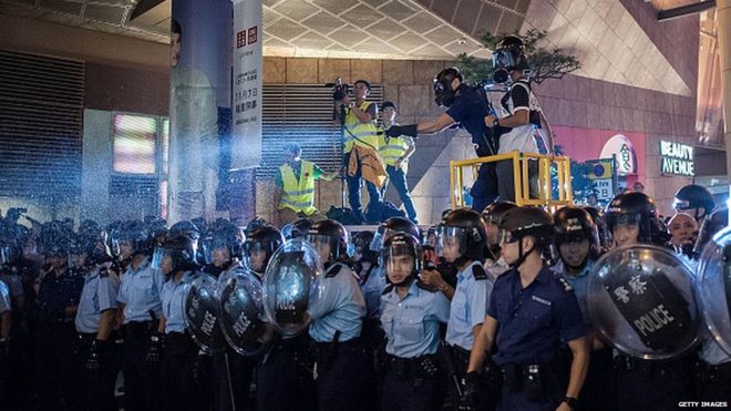 ОМОН использует слезоточивый спрей во время столкновения с протестующими в районе Монгкок 25 ноября 2014 года в Гонконге
