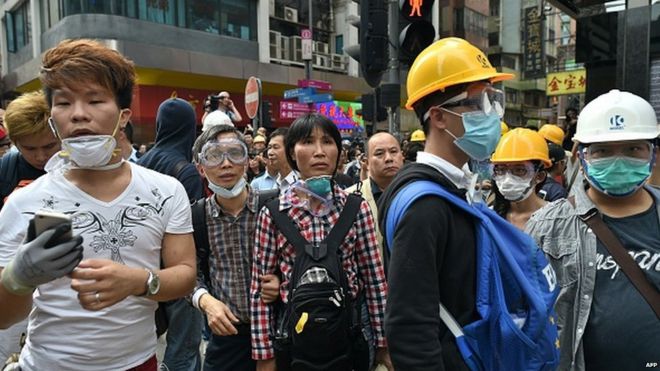 Протестующие за демократию следят за тем, как полиция в районе Монгкок Гонконг разминирует крупный участок протеста 26 ноября 2014 года