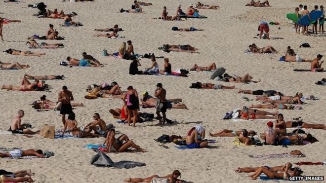 Фото из архива: представители общественности наслаждаются теплой погодой на пляже Бонди в Сиднее, Австралия, 31 октября 2014 года
