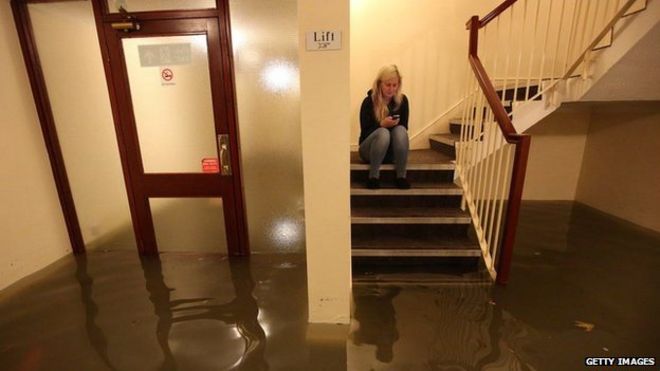 Женщина по телефону в затопленной бостонской квартире