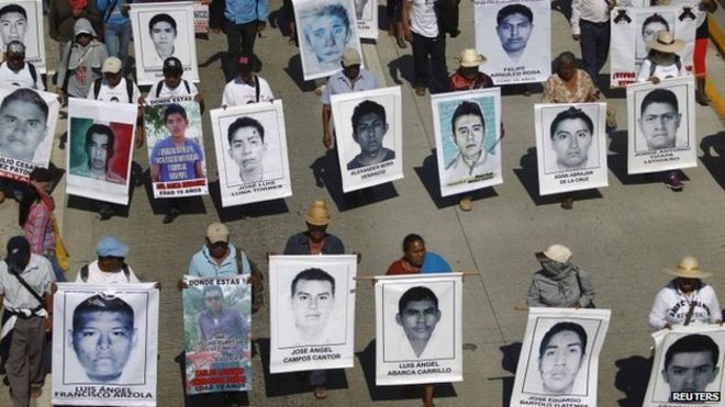 Родственники держат фотографии пропавших студентов в Чилпансинго 2 декабря 2014 года.