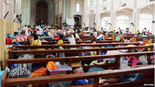 Люди покидают свои дома в церкви после того, как покинули свои дома из-за супер-тайфуна Хагупит в городе Таклобан, центральные Филиппины 5 декабря 2014 г.
