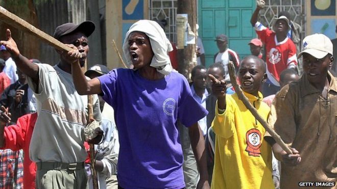 Вооруженные молодые люди, принадлежащие к племени кикуйю, издеваются над конкурирующей бандой, состоящей из мужчин разной этнической принадлежности, в городе Найваша, провинция Рифт-Валли, в 2008 году