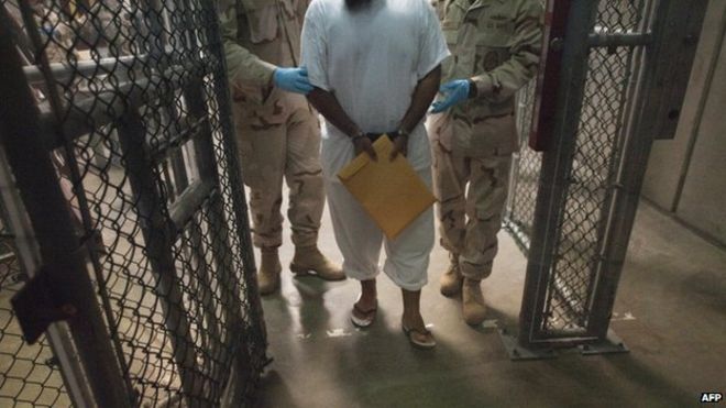 Фото из архива показывает, что американские военные охранники перемещают задержанного в залив Гуантанамо, Куба, в 2010 году.