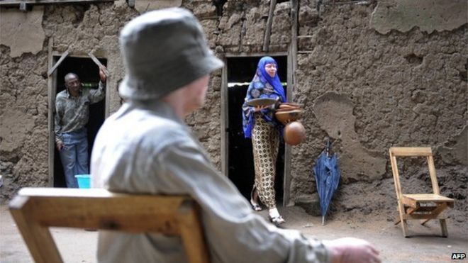 28-летняя Нима Каджанья несет 27 января 2009 г. керамические горшки, которые она продает для проживания в доме своей бабушки, где она и двое братьев и сестер, оба альбиносы, живут в Укереве