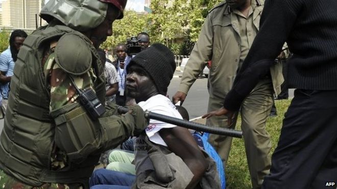 Полицейские арестовывают человек, протестующий о спорном новом законодательстве по вопросам безопасности за пределами парламента 18 18 декабря 2014 в Найроби, Кения