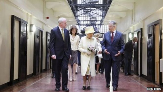 Королева Елизавета (C) во время прогулки с первым министром Северной Ирландии Питером Робинсоном (справа) и заместителем первого министра Мартином МакГиннессом во время посещения тюрьмы Crumlin Road в Белфасте