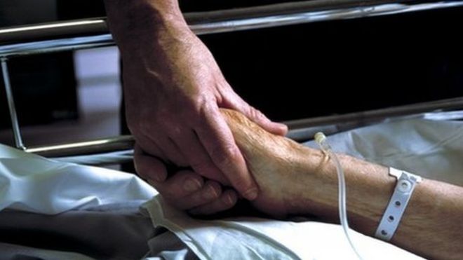 Медсестра держит руку пациента