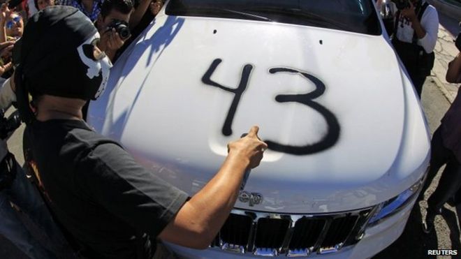 Демонстрант распыляет номер 43 на капот автомобиля, принадлежащего конгрессмену Хорхе Сальгадо во время акции протеста в Чильпансинго 7 января 2015 года