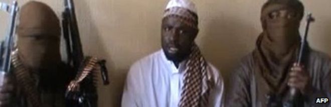 Снимок экрана, снятый из видео, выпущенного на YouTube в апреле 2012 года, на котором, видимо, изображен лидер «Боко харам» Абубакар Шекау (в центре), сидящий в окружении боевиков