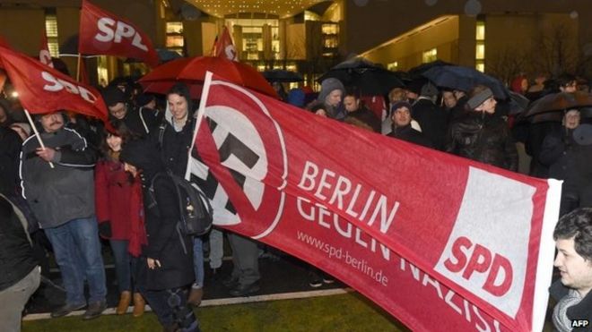 Члены немецкой социал-демократической партии СДПГ держат плакат с изображением перекрещенной свастики и надписью «Берлин против нацистов». во время митинга протеста против немецкого движения против исламизации "Патриотические европейцы против исламизации Запада" ПЕГИДА, 12 января 2015 года возле Канцелярии в Берлине