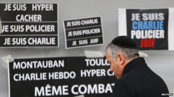 Мужчина отдает дань памяти жертвам парижских терактов