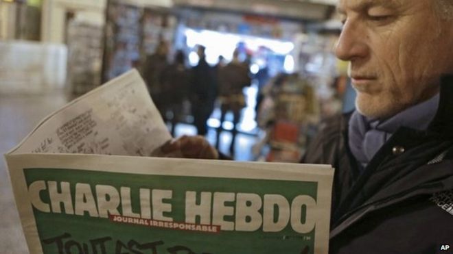 Мужчина читает первый номер французского журнала Charlie Hebdo, поскольку 12 человек погибли в результате нападения на его офисы (14 января 2015 года)
