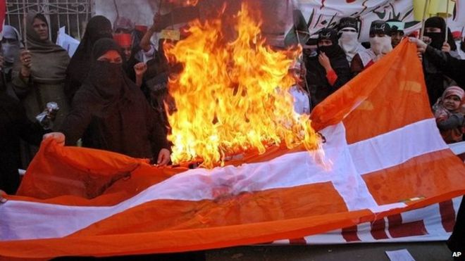 Пакистанцы сжигают датский флаг во время акции протеста в Лахоре против публикации карикатур на пророка Мухаммеда (24 февраля 2006 года)