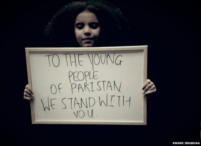 Британская девушка держит знак солидарности с пакистанскими детьми