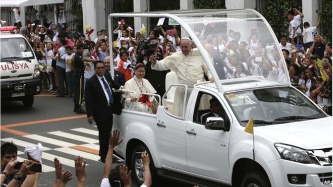 Папа Фрэнсис машет верующим от своего папамобиля, когда его автоколонна покидает Президентский дворец в Манильском соборе в пятницу, 16 января 2015 года в Маниле, Филиппины.