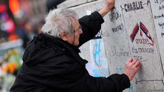 Один демонстрант в Париже пишет некоторые граффити #JeSuisCharlie