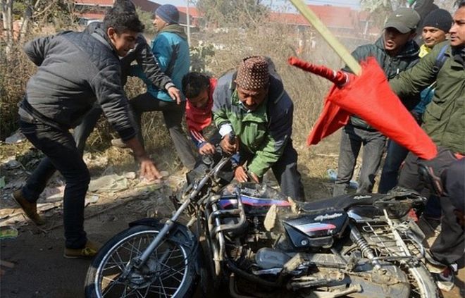 Сторонники непальского альянса, возглавляемого Объединенной коммунистической партией Непала (маоистской), вандализируют мотоцикл во время однодневной общенациональной забастовки в Катманду 20 января 2015 года