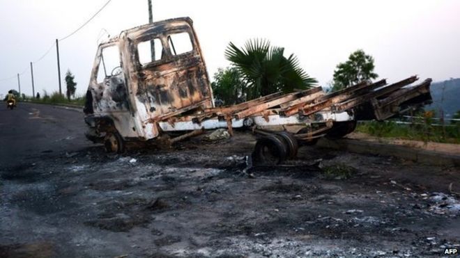 На снимке: сгоревший грузовик на дороге, ведущей в Университет Киншасы, где 19 января 2015 года в Киншасе прошли демонстрации протеста против действий, которые позволили президенту Демократической Республики Конго продлить свою власть.