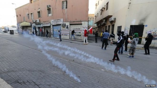 Протестующие укрываются от слезоточивого газа, выпущенного ОМОНом во время столкновений в деревне Билад Аль-Кадим, к югу от Манамы 20 января 2015 года